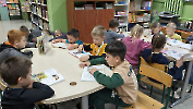 Uczniowie oglądają książki w bibliotece